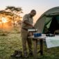 Safari guide prepares morning coffee at tent